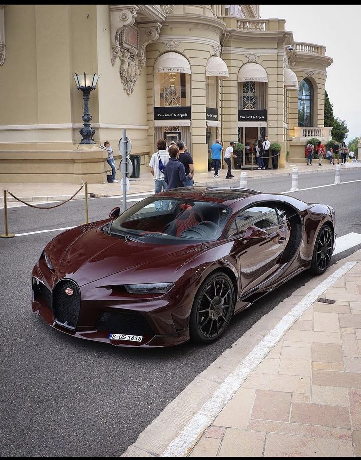 a bugatti is parked on the side of the road in front of a building