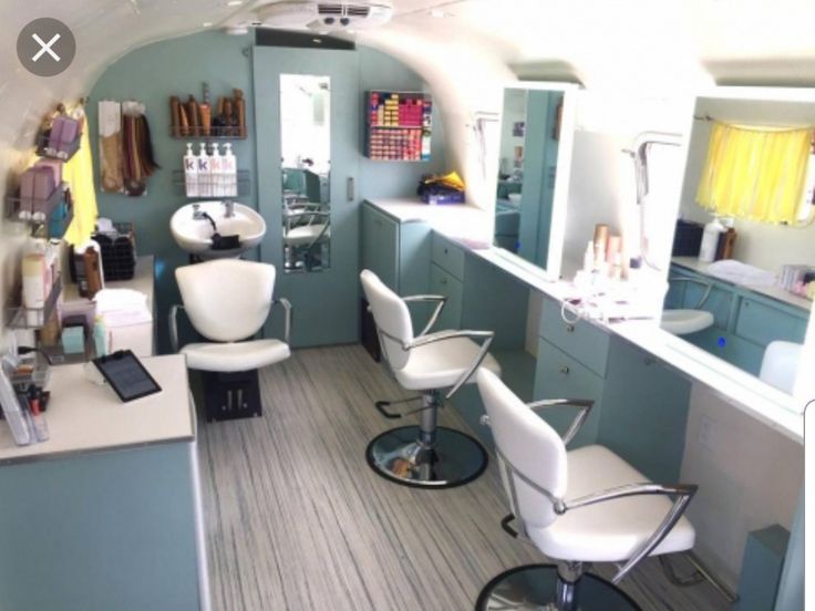 the interior of a hair salon with white chairs