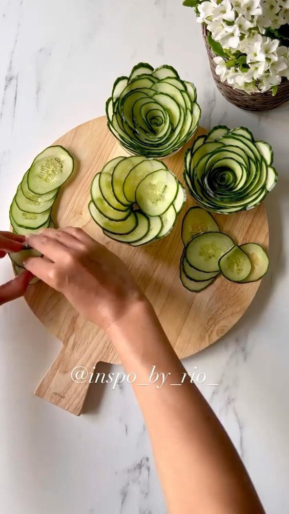 someone cutting cucumbers on a wooden board