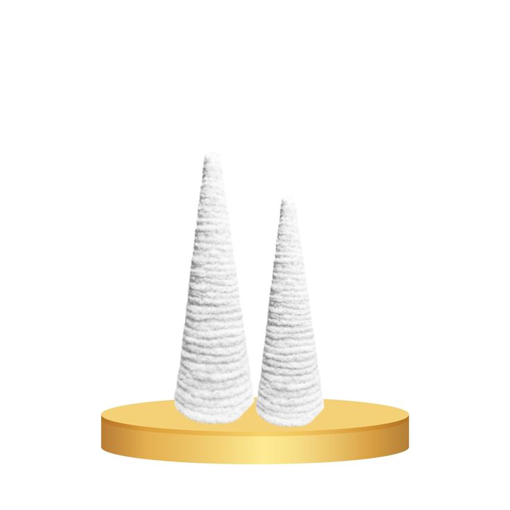 two white cones sitting on top of a gold base