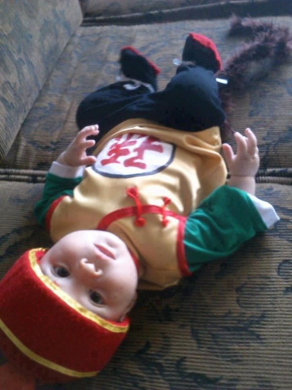 a baby laying on top of a couch next to a stuffed animal