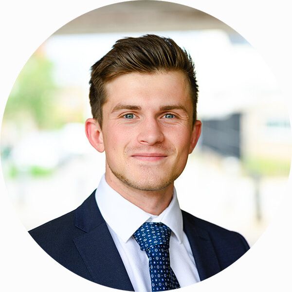 a man in a suit and tie is smiling for the camera while wearing a blue polka dot tie