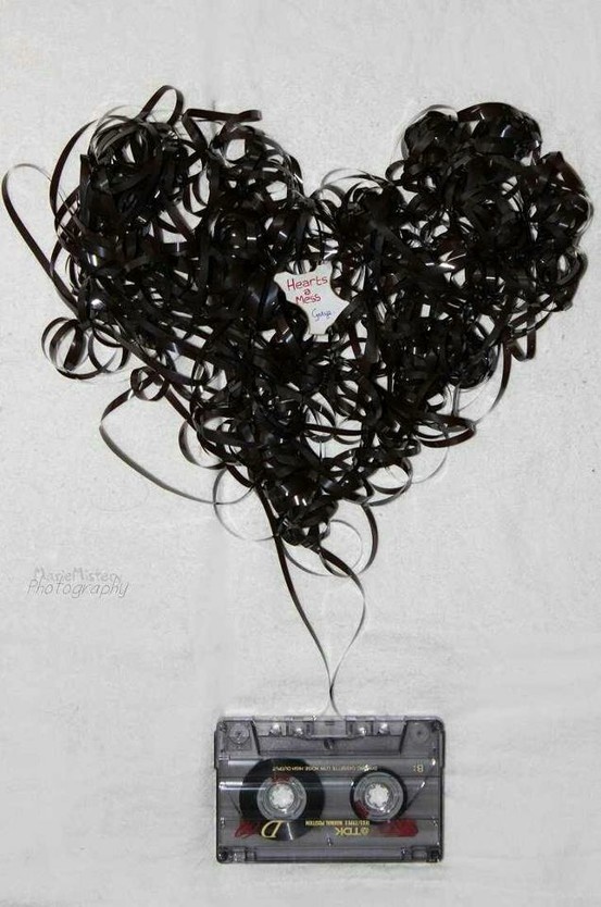 a heart made out of black hair next to an old tape recorder on a white background