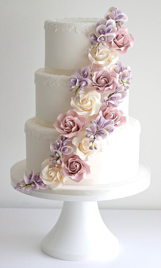 a three tiered wedding cake with flowers on it