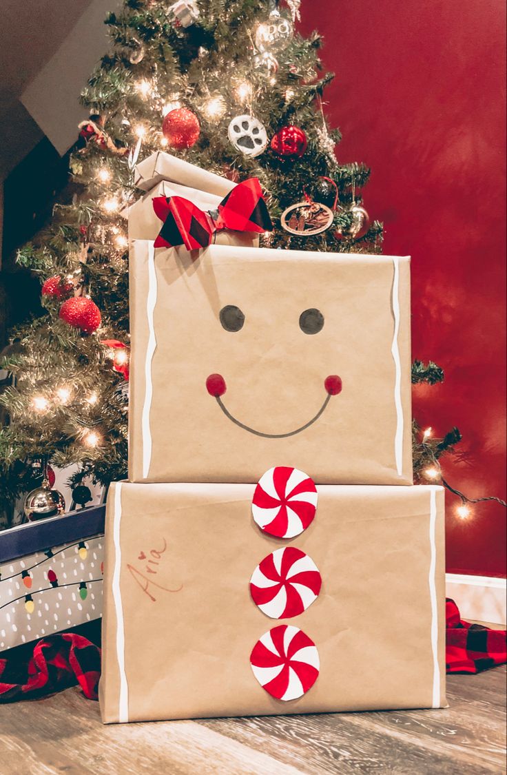 a christmas tree with presents wrapped in brown paper and a smiling face on the front