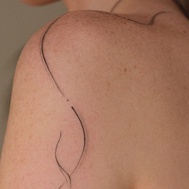 the back of a woman's shoulder with a tattoo on it