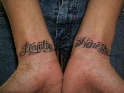 two people with matching tattoos on their arms that say, togetherness and honesty written in cursive font