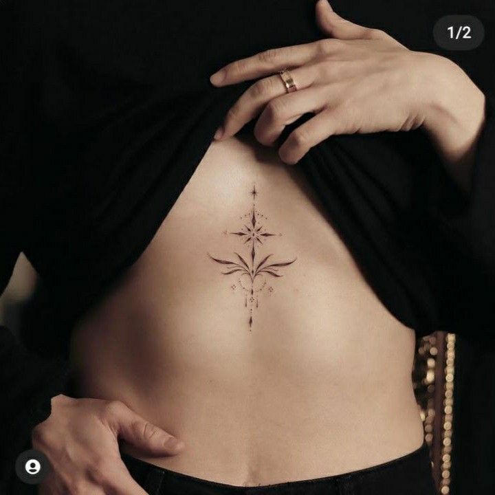 a woman's stomach with a cross tattoo on her belly and the bottom part of her lower back