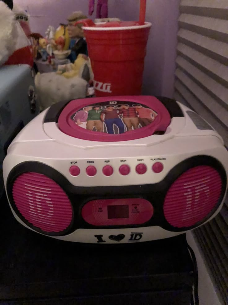 a pink and white boombox sitting on top of a shelf next to a teddy bear