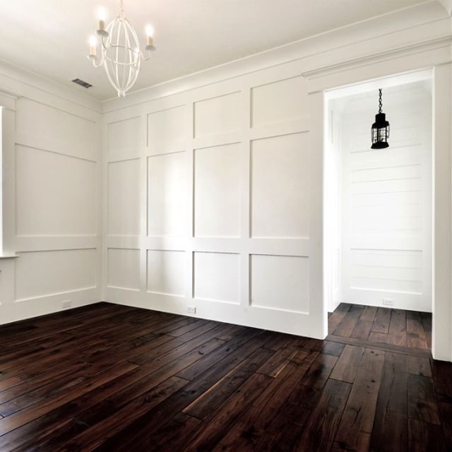 an empty room with hard wood floors and white paneling on the walls is shown