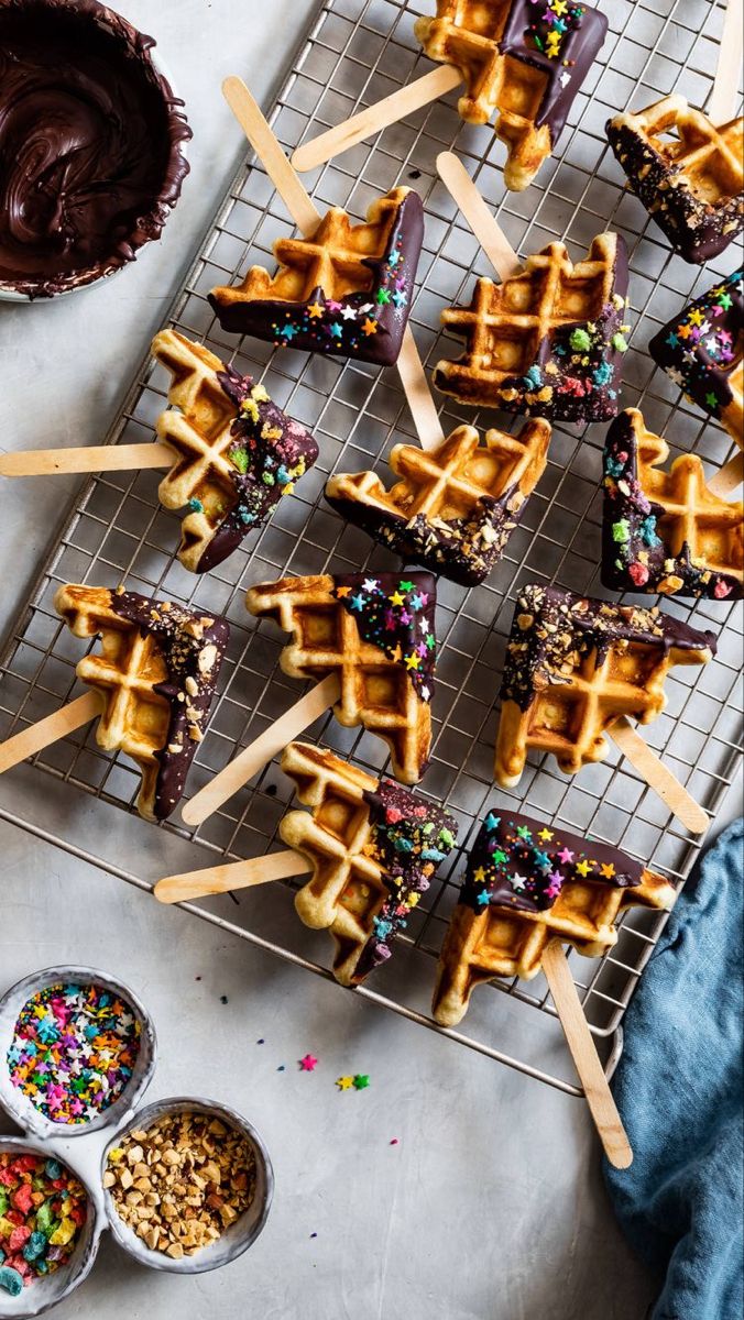 chocolate covered waffles with sprinkles and toppings on a cooling rack