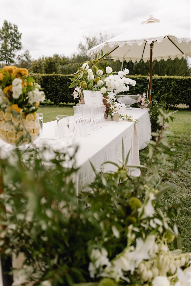 a table with an umbrella and flowers on it