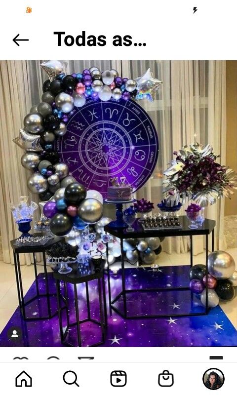 a table topped with balloons and other items on top of a purple floor covered in stars