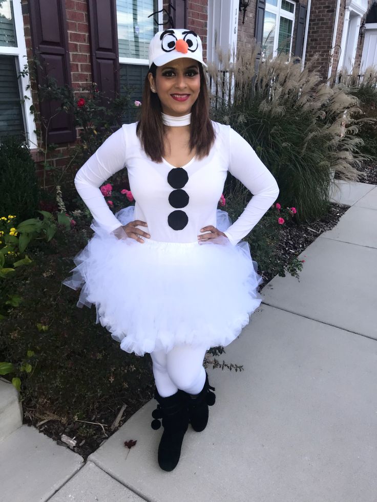 a woman dressed in a costume standing on the sidewalk with her hands on her hips