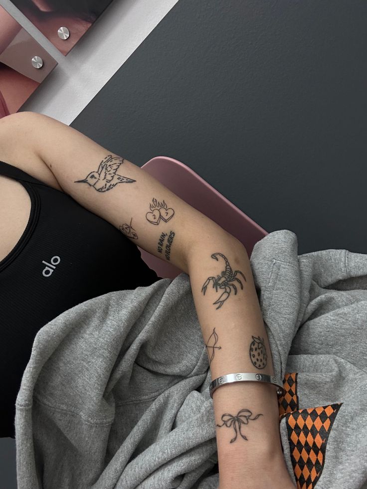 a woman with tattoos on her arm laying down