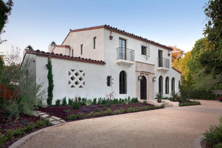 a large white house surrounded by trees and bushes