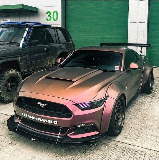 two cars parked next to each other in front of a garage