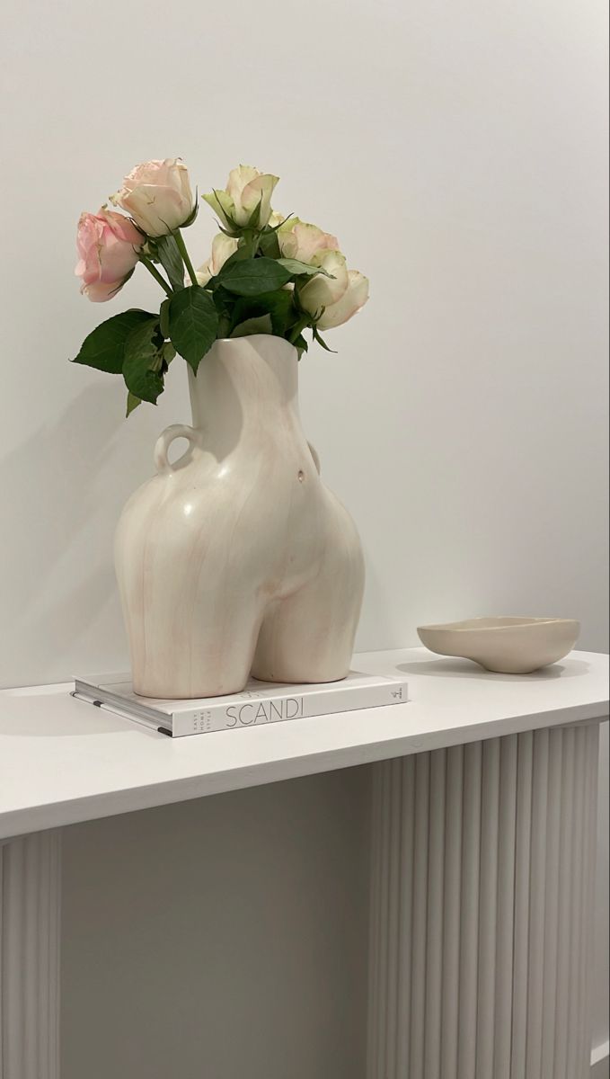 a white vase with some flowers in it