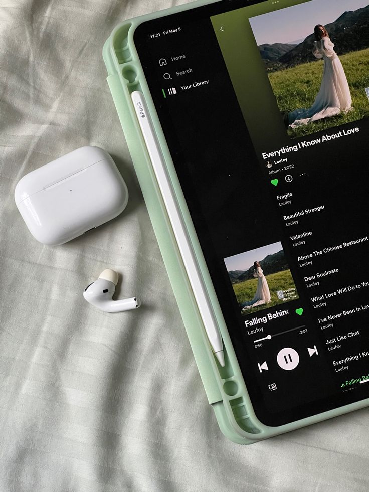 an apple airpods sitting on top of a bed next to headphones and earbuds