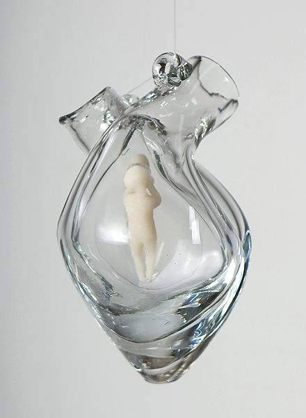 an ornament shaped like a human being in a glass vase