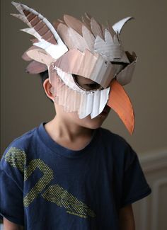 a young boy wearing a paper mask made to look like a bird