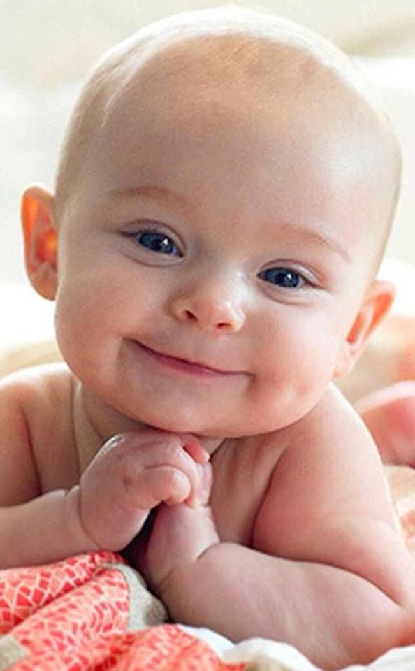 a smiling baby laying on top of a bed next to a quote that says, kak a bac beck