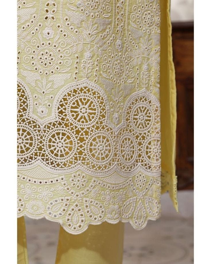 a yellow dress with white lace on it