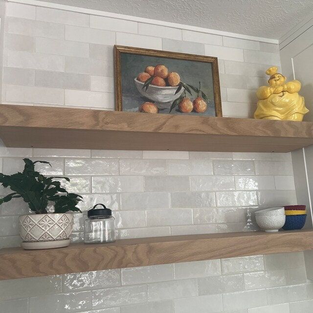 two wooden shelves with pots and bowls on them in a white tiled kitchen, next to a yellow duck statue