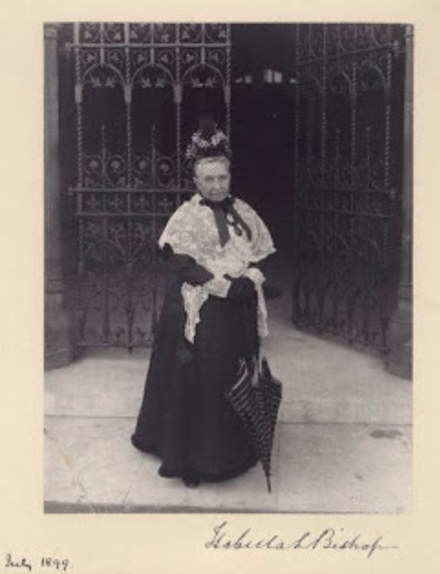 an old black and white photo of a woman wearing a long dress with a crown on her head