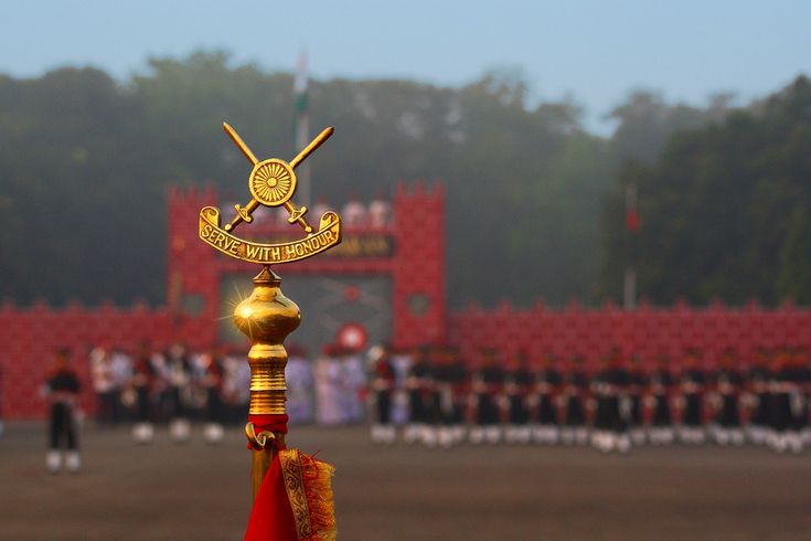 a group of people standing in front of a red and gold building with two flags on it