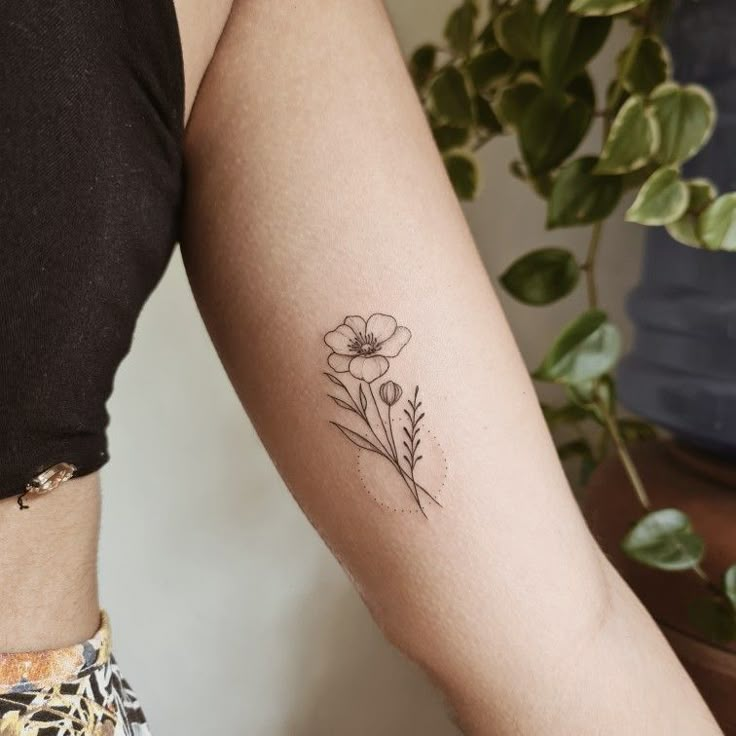 a woman's arm with a flower tattoo on the left side of her arm