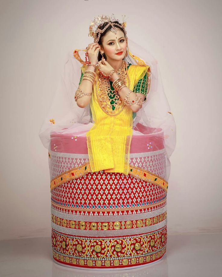 a statue of a woman sitting on top of a colorful box with a veil over her head