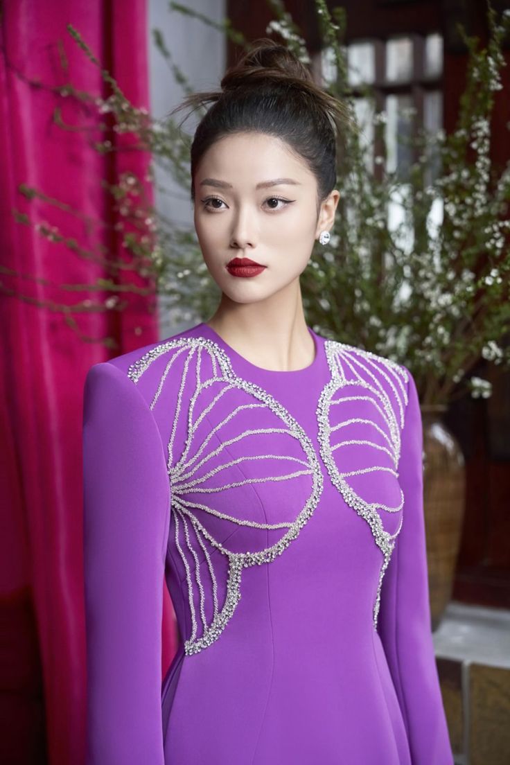 Indulge in the luxurious sophistication of our Ao Dai. The shimmering velvet and satin fabrics create a luminous effect, while the A-line cut and floor length silhouette offer a flattering and elegant look. Experience the beauty and grace of this exquisite piece. Length: 150cm (Ao Dai), 110cm (Pants) Elegant Purple Evening Dress For Banquets, Elegant Purple Evening Dress For Banquet, Elegant Purple Gown For Banquet, Luxury Purple Evening Dress For Wedding, Elegant Purple Gown For Gala, Elegant Purple Evening Gown, Elegant Embellished Purple Evening Dress, Luxury Women's Embellished Ao Dai, Luxury Silk Evening Dress For Festive Season