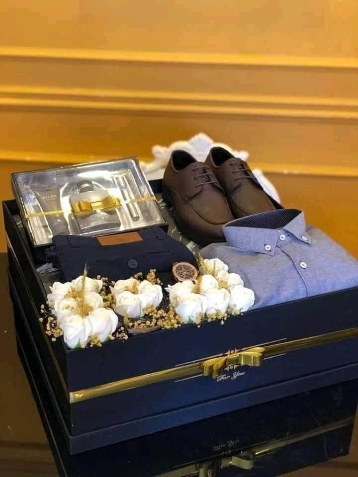 a pair of brown shoes sitting on top of a blue box next to white flowers