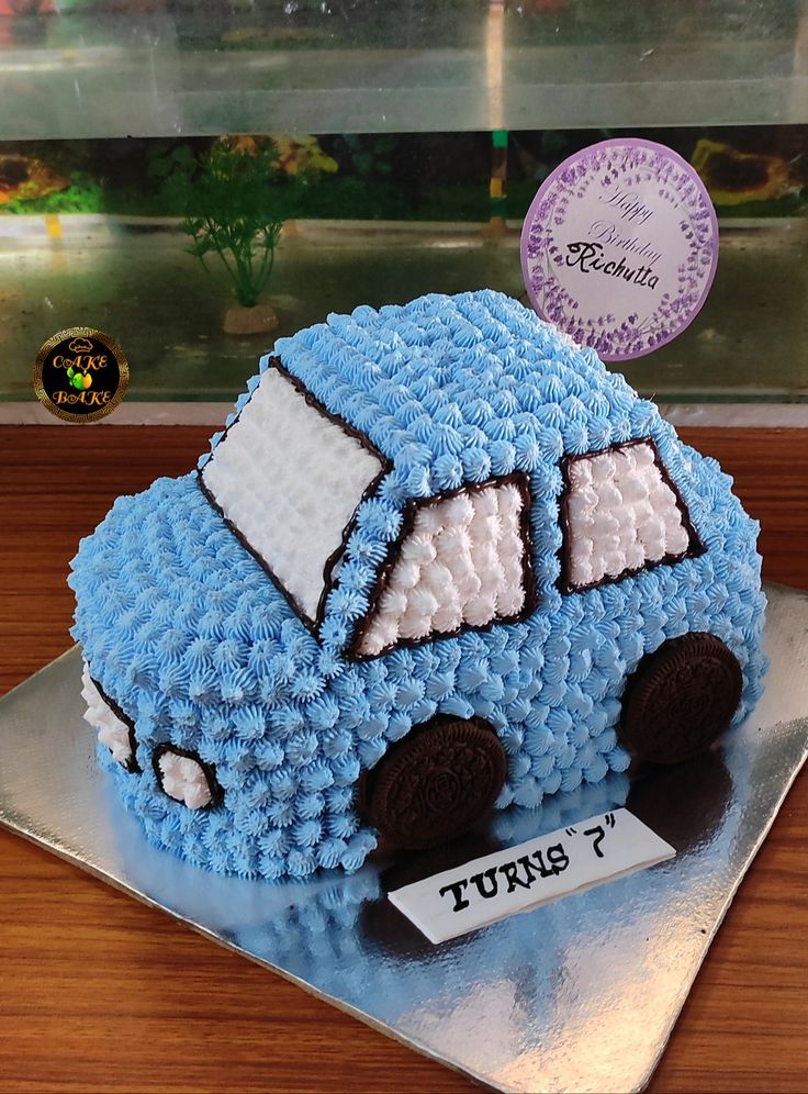 a blue cake with white frosting cars on it