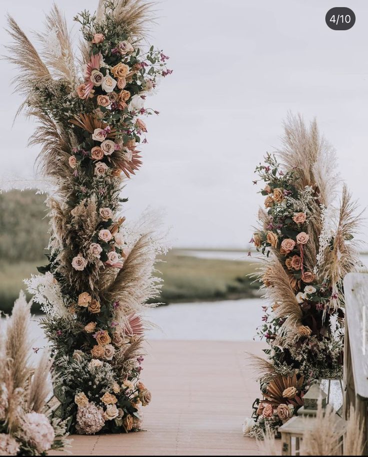 an outdoor ceremony setup with flowers and pamodia in the foreground, next to a lake