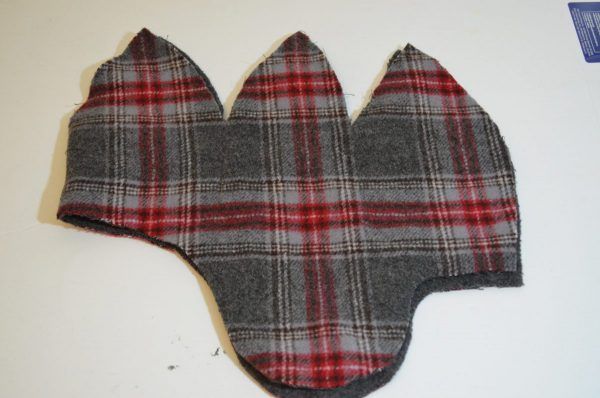 a gray and red plaid hat on top of a white table