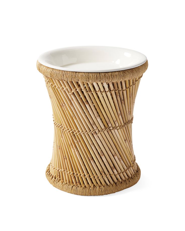 a wicker basket with a white bowl on the top and bottom, sitting in front of a white background