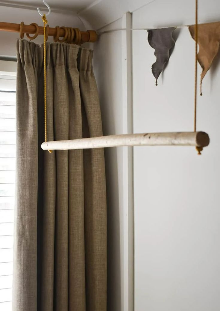 a curtain rod hanging from the ceiling next to a window