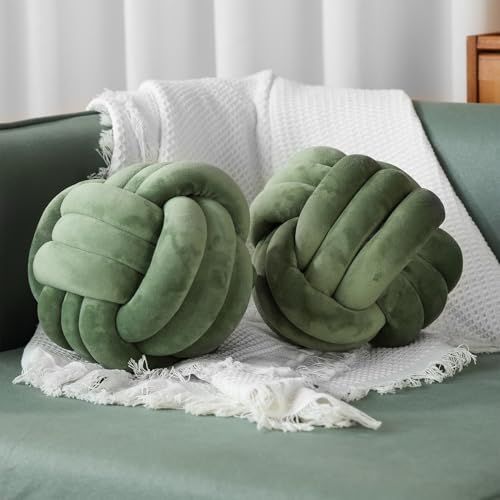 two green pillows sitting on top of a bed