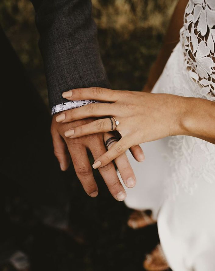 the bride and groom are holding hands with their wedding rings on their fingernails