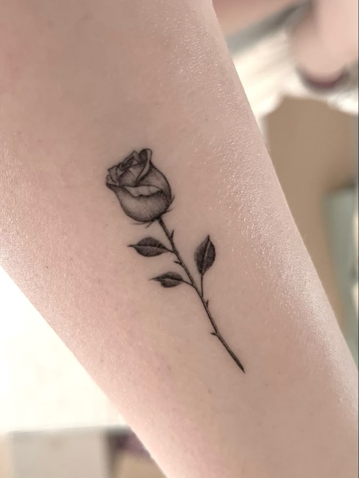 a small rose tattoo on the leg