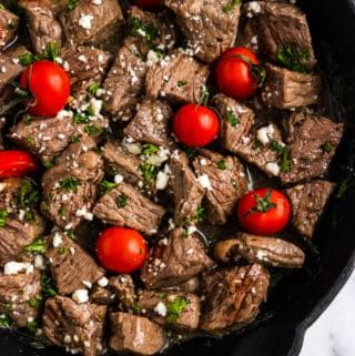 a skillet filled with meat and tomatoes