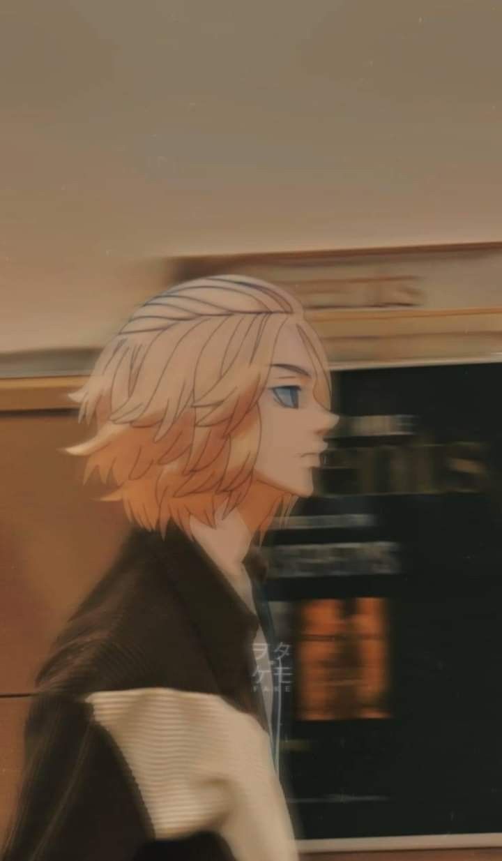 a man with blonde hair and blue eyes is walking down the street in front of a train