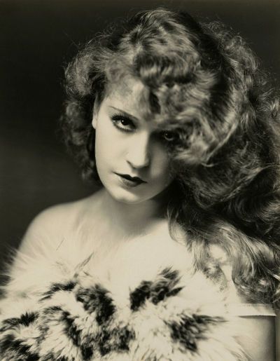 black and white photograph of a woman with long hair holding an owl fur stoler