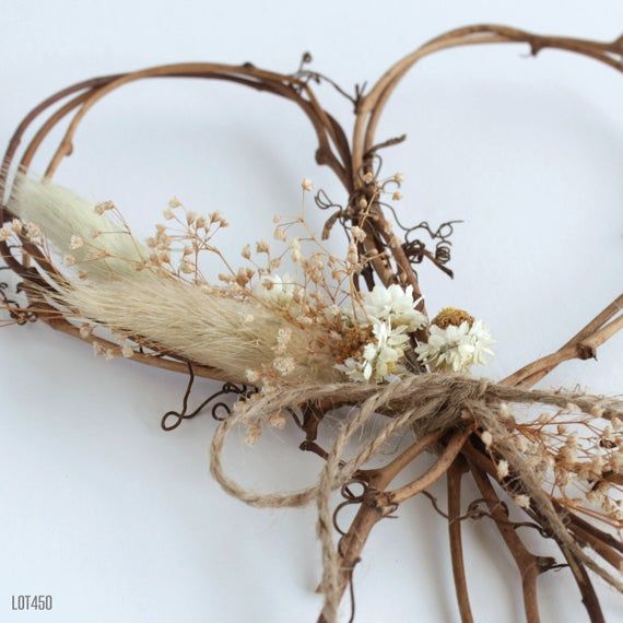 dried flowers and twigs are arranged on a white surface