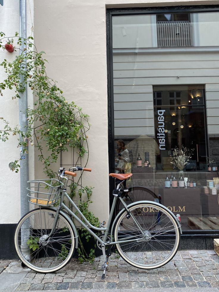 a bicycle parked in front of a building with plants growing out of it's windows