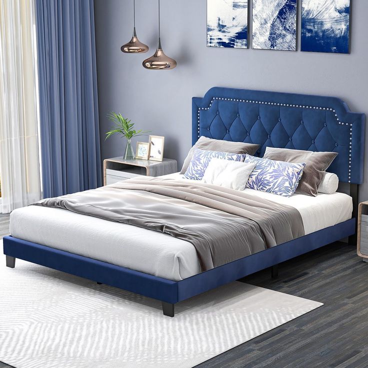 a bed with blue headboard and foot board in a bedroom next to a window