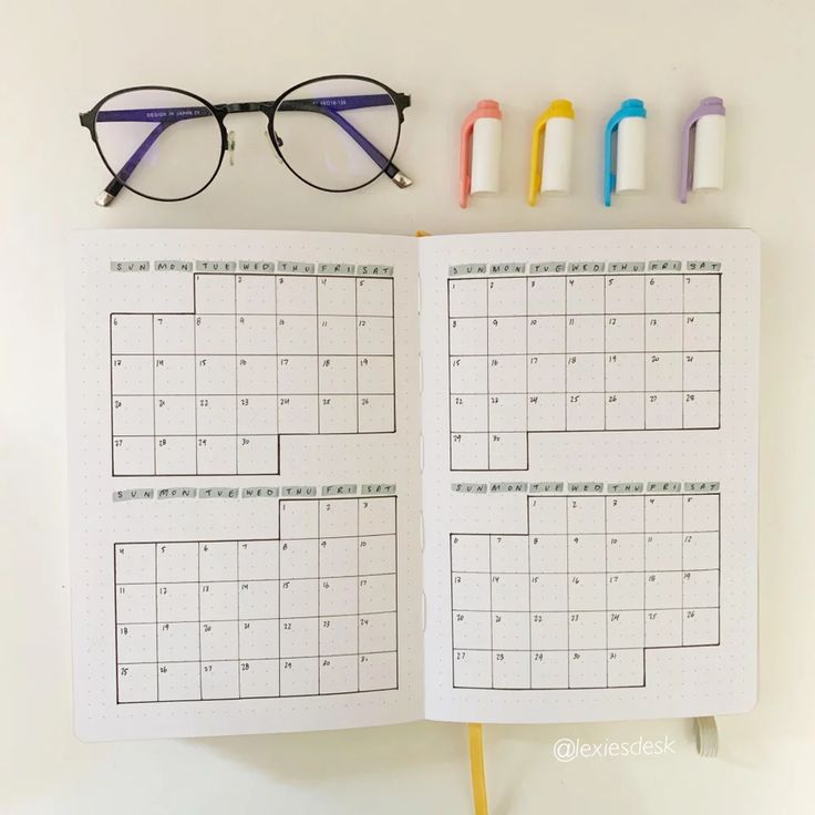 an open planner with glasses on top