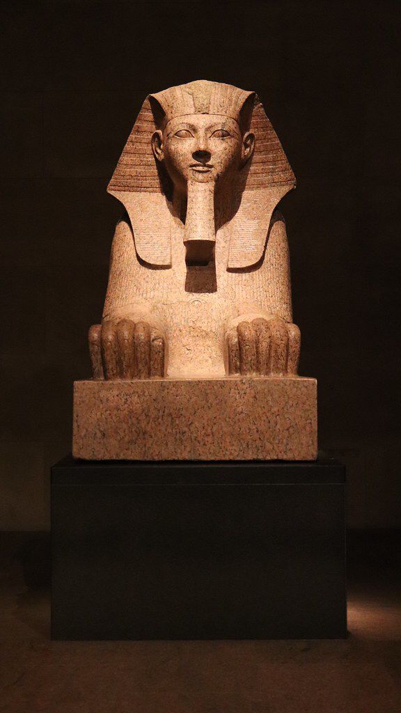 the statue of an egyptian pharaoh is on display in front of a dark background,